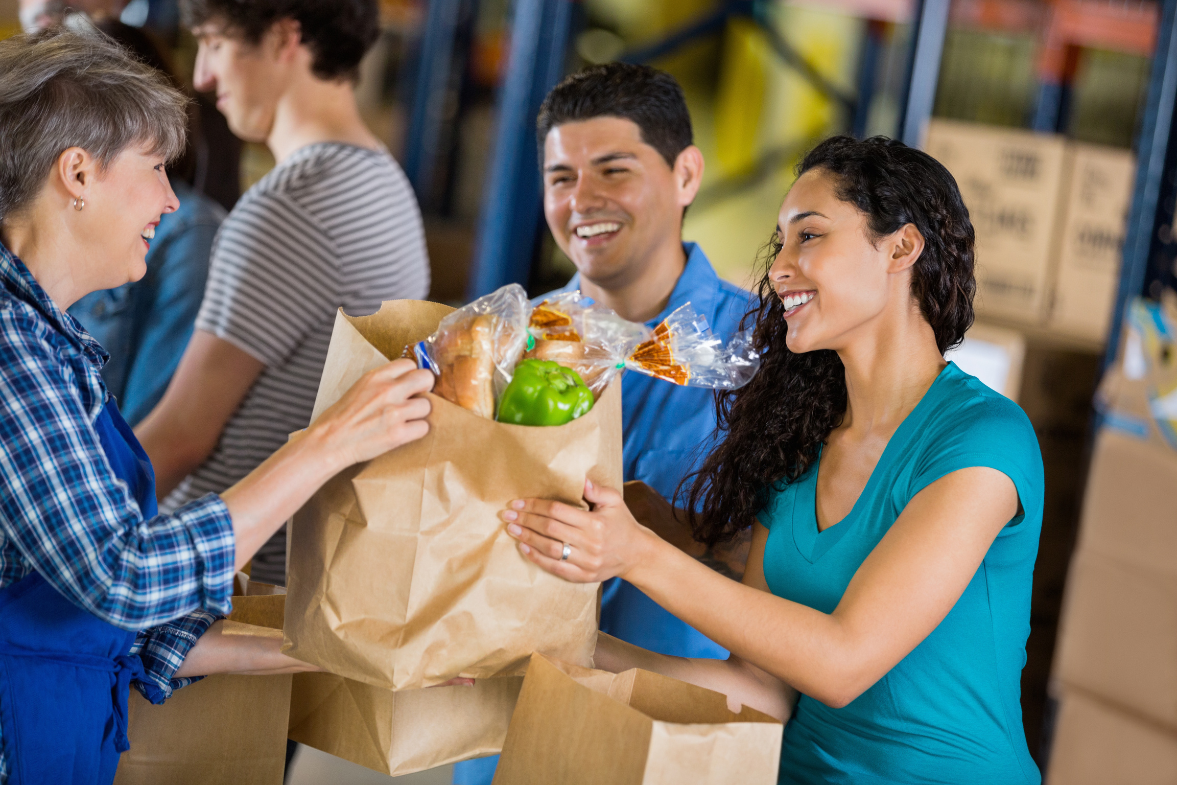 Diverse volunteers giving donations at food bank